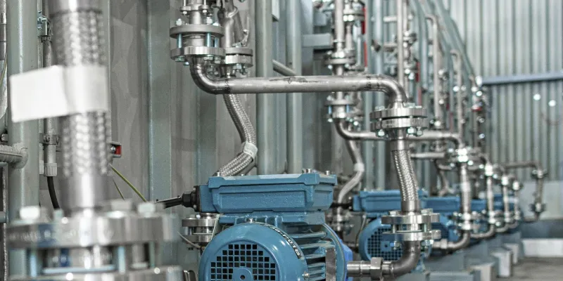 Detail of new blue electric motors with pumps on the stainless steel production line.